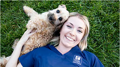 Mujer tumbada con un perro sobre la hierba